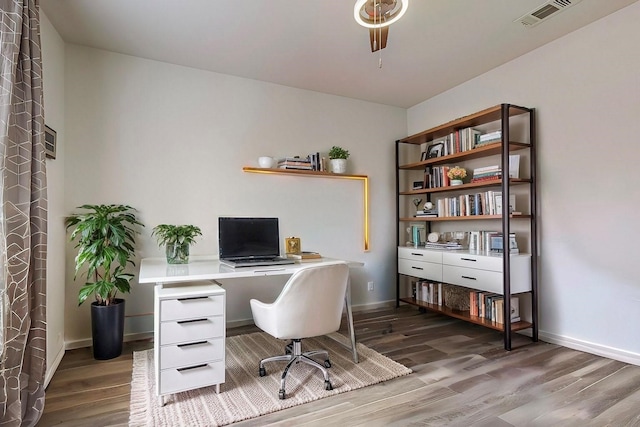 office area featuring wood finished floors, visible vents, and baseboards