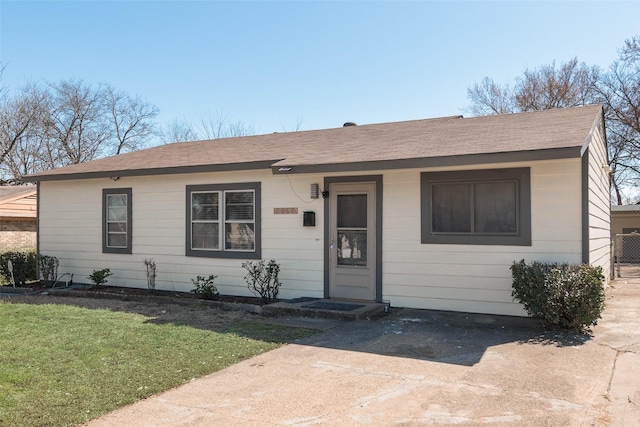 view of front of property with a front lawn and a shingled roof