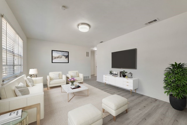 living room featuring light wood-style flooring and visible vents