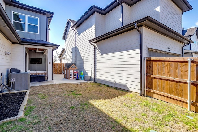 view of home's exterior featuring central air condition unit, a lawn, an attached garage, a patio area, and fence