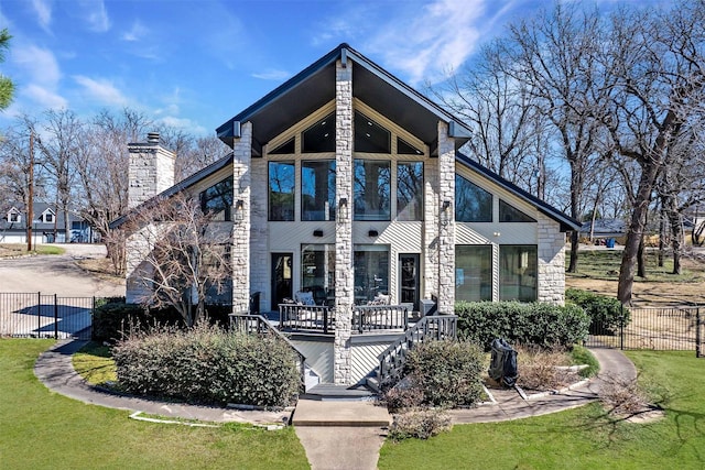 mid-century home with a chimney, a front yard, and fence