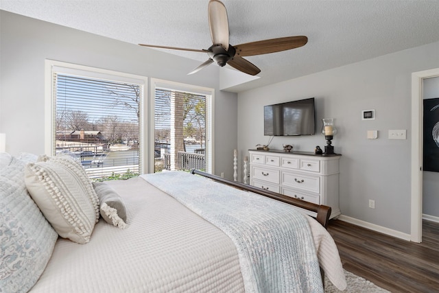 bedroom featuring dark wood finished floors, a textured ceiling, baseboards, and ceiling fan