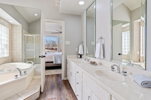 bathroom with visible vents, a sink, a garden tub, and wood finished floors