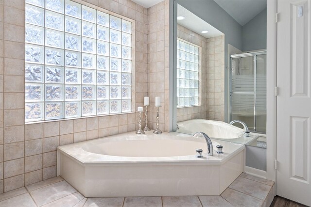 full bath featuring tile patterned flooring, a shower stall, a bath, and tile walls