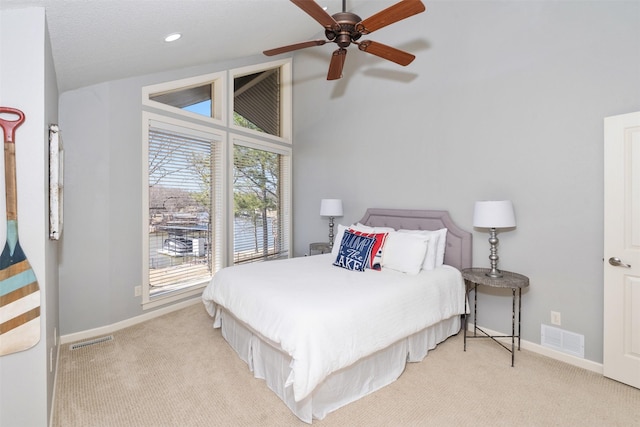 bedroom with baseboards, visible vents, and light colored carpet