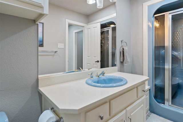 bathroom featuring a textured wall, a shower stall, and vanity