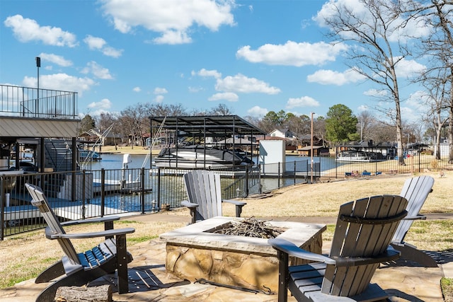 view of dock featuring a water view, an outdoor fire pit, fence, and boat lift