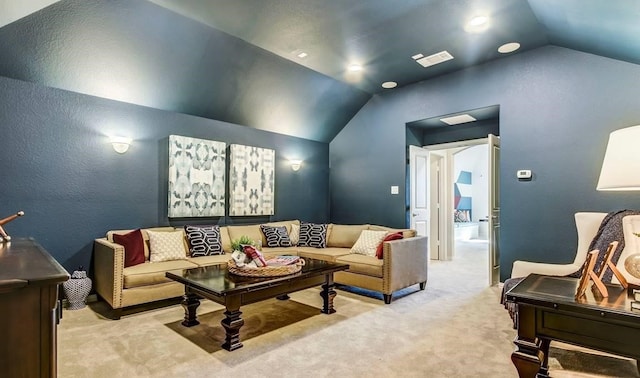 home theater with lofted ceiling, a textured wall, light carpet, and visible vents