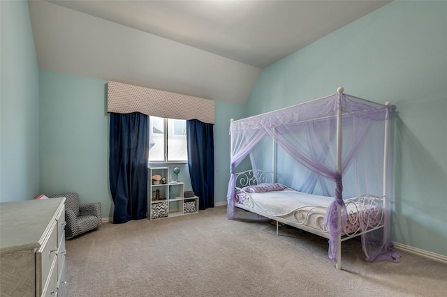 bedroom featuring lofted ceiling, baseboards, and carpet flooring