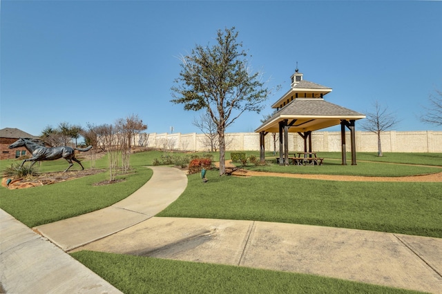 view of property's community with a gazebo, a fenced backyard, and a yard