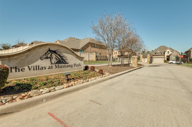 community / neighborhood sign with fence and a residential view