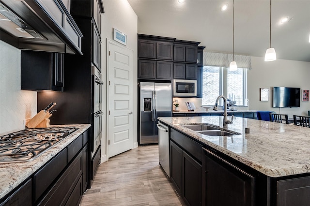 kitchen featuring stainless steel appliances, a sink, custom exhaust hood, and light stone countertops