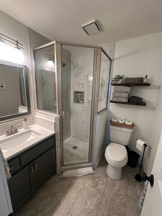 full bath with a textured ceiling, toilet, vanity, marble finish floor, and a shower stall