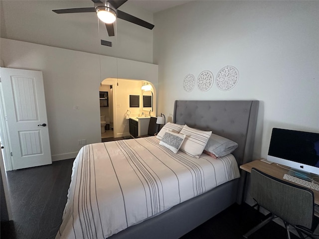 bedroom with a ceiling fan, dark wood finished floors, visible vents, baseboards, and ensuite bath