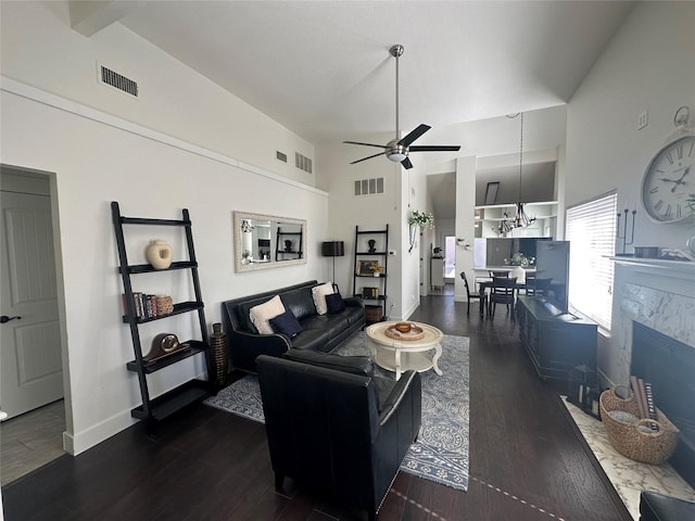 living room featuring visible vents, dark wood finished floors, and ceiling fan with notable chandelier