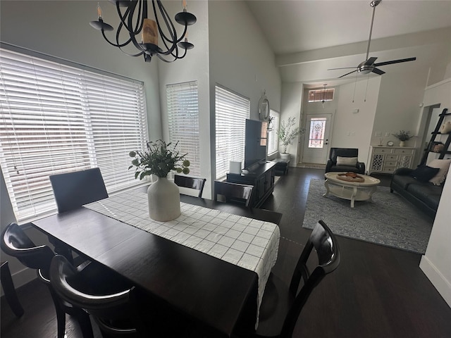 dining area with a towering ceiling, baseboards, and ceiling fan with notable chandelier