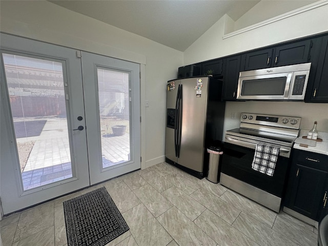 kitchen featuring lofted ceiling, dark cabinets, light countertops, appliances with stainless steel finishes, and french doors