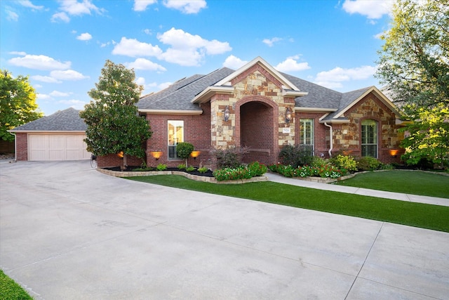 view of front of house with stone siding, roof with shingles, a front yard, and brick siding