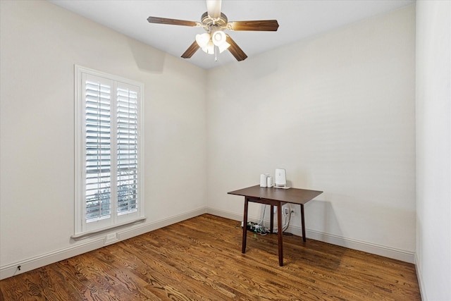 spare room featuring ceiling fan, baseboards, and wood finished floors