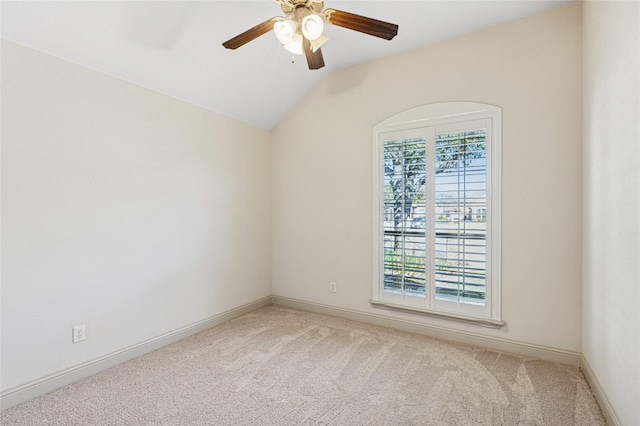 carpeted empty room with baseboards, vaulted ceiling, and a ceiling fan