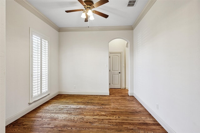 spare room with arched walkways, a wealth of natural light, visible vents, and crown molding