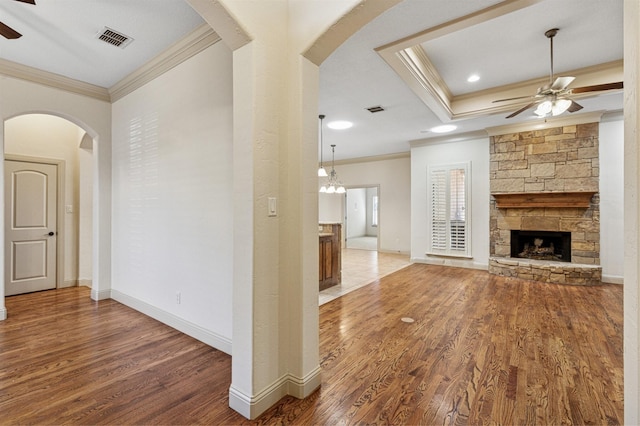 unfurnished living room with crown molding, wood finished floors, visible vents, and a ceiling fan