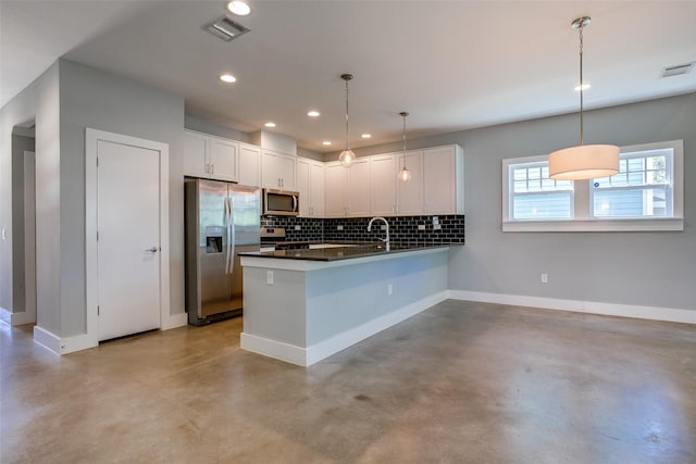 kitchen featuring appliances with stainless steel finishes, dark countertops, white cabinetry, and decorative light fixtures