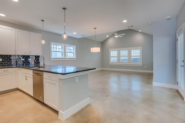 kitchen featuring open floor plan, stainless steel dishwasher, dark countertops, and white cabinets