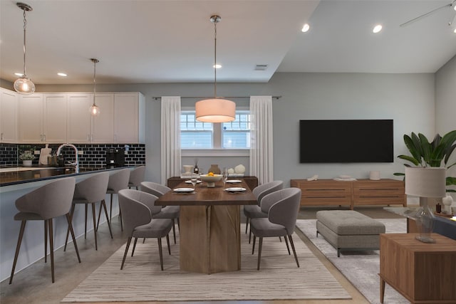 dining room featuring concrete floors, visible vents, and recessed lighting