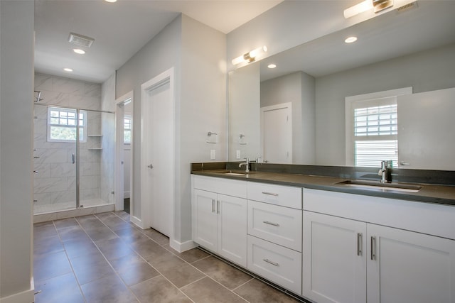 bathroom featuring double vanity, a stall shower, a sink, and recessed lighting