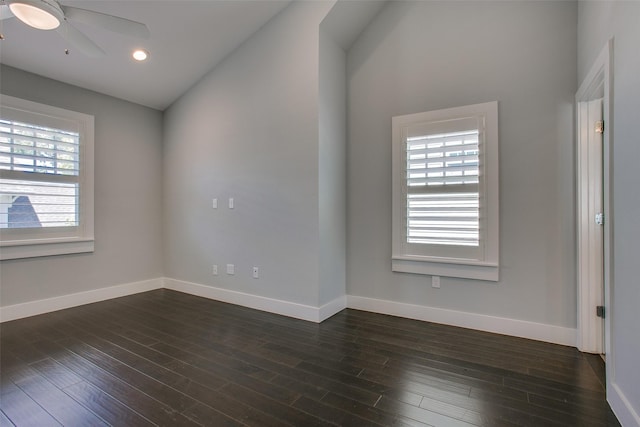 empty room with dark wood-style floors, a ceiling fan, and baseboards