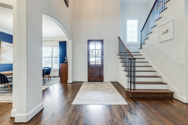 entrance foyer featuring ornamental molding, plenty of natural light, and dark wood finished floors