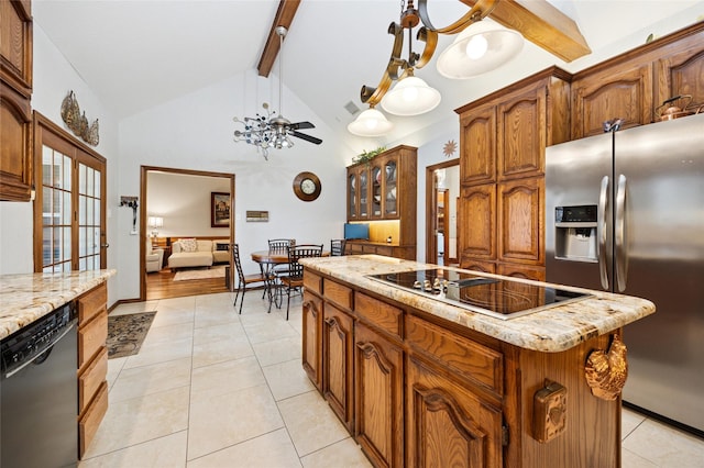 kitchen featuring light tile patterned floors, a kitchen island, beamed ceiling, decorative light fixtures, and black appliances