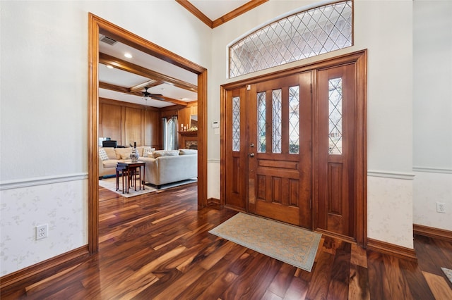 foyer with wallpapered walls, baseboards, a wainscoted wall, ornamental molding, and dark wood-style flooring