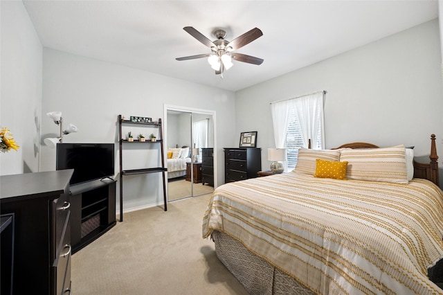 bedroom featuring light carpet, a closet, and a ceiling fan