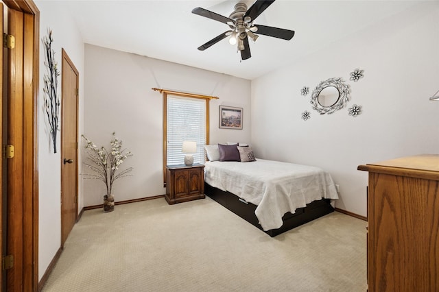 bedroom featuring a ceiling fan, light carpet, and baseboards