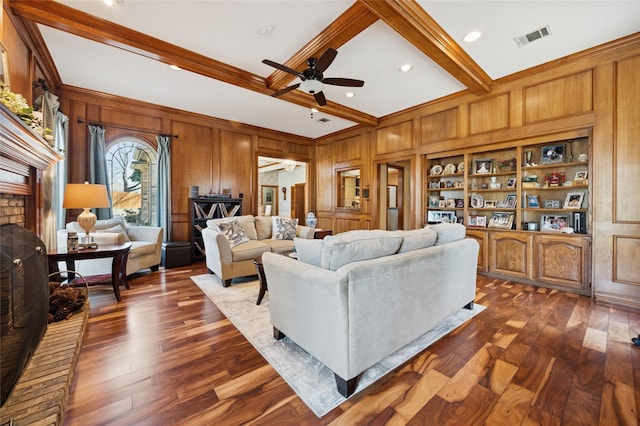 living area with visible vents, dark wood-style flooring, wood walls, built in shelves, and beam ceiling