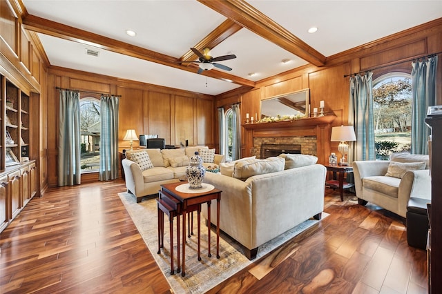 living area featuring a healthy amount of sunlight, a fireplace, and beam ceiling