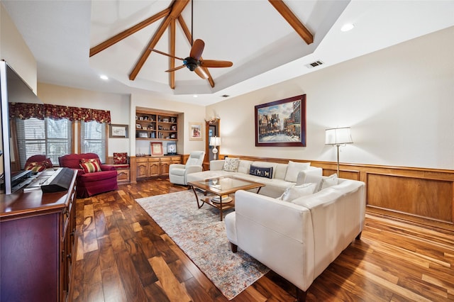 living area with a wainscoted wall, vaulted ceiling with beams, recessed lighting, visible vents, and wood finished floors