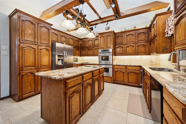 kitchen with a kitchen island, appliances with stainless steel finishes, decorative backsplash, and a sink