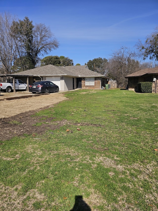 view of yard with an attached garage and dirt driveway