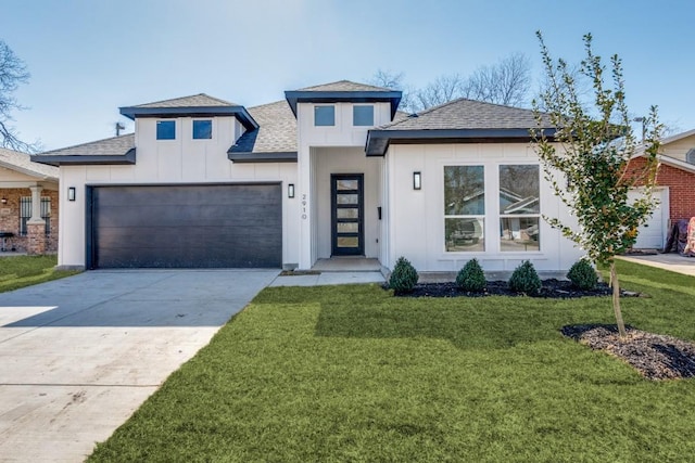 view of front of house featuring concrete driveway, roof with shingles, an attached garage, a front lawn, and board and batten siding