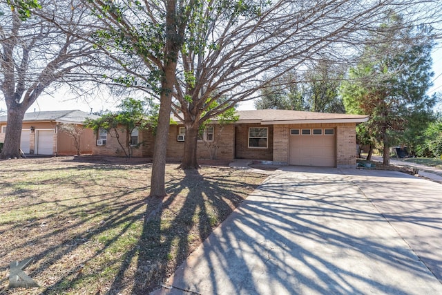 ranch-style house with a garage, concrete driveway, brick siding, and a front yard