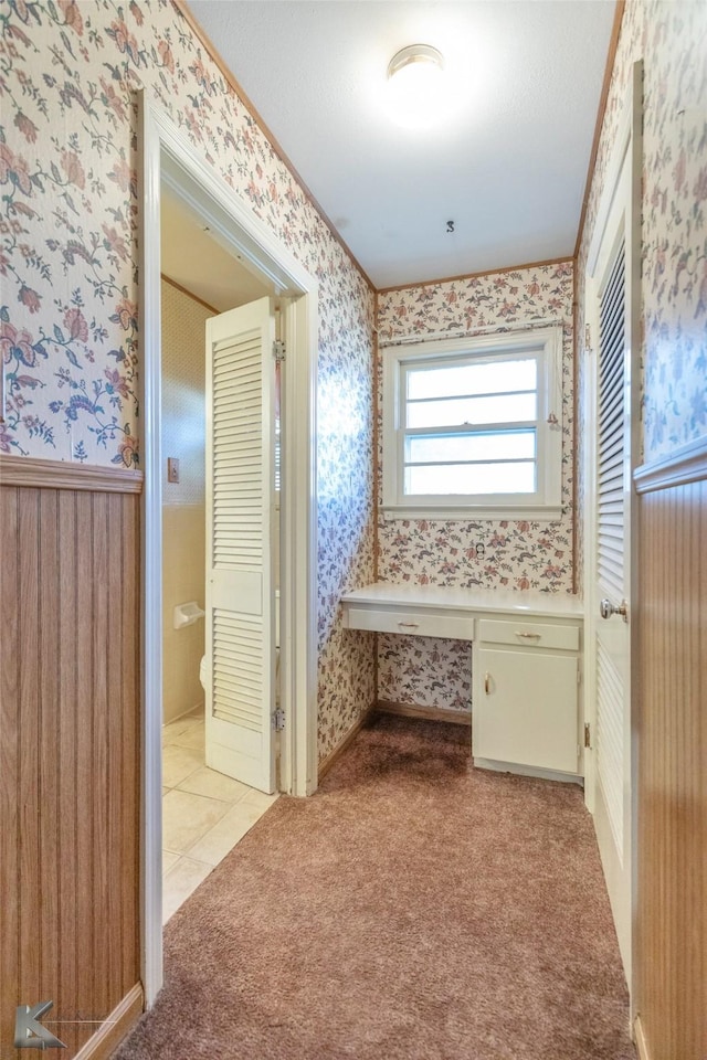 bathroom featuring wainscoting and wallpapered walls