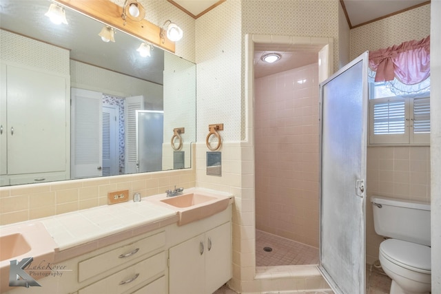 full bath featuring a stall shower, double vanity, tile walls, and wallpapered walls