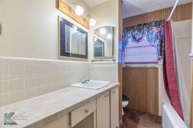 bathroom with tile walls, wainscoting, and vanity