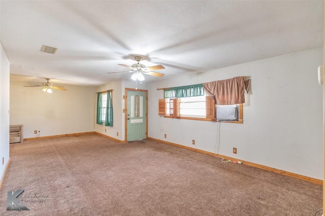 spare room with carpet, visible vents, a textured ceiling, and baseboards