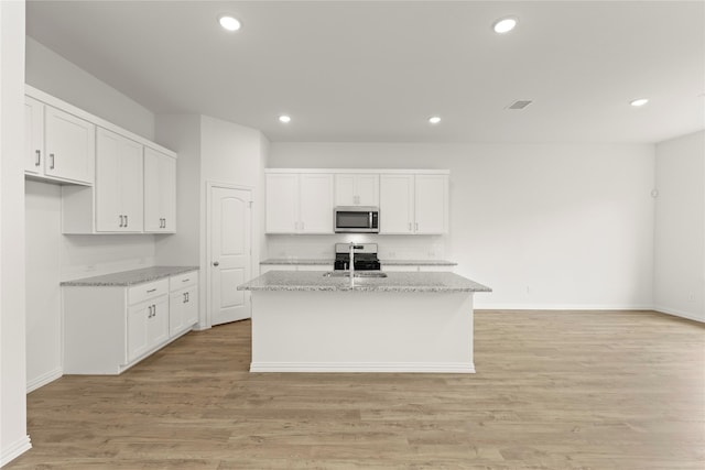 2720 Green River Rd, Royse City, TX 75189 - kitchen featuring appliances with stainless steel finishes, white cabinets, a center island with sink, light stone countertops, and recessed lighting