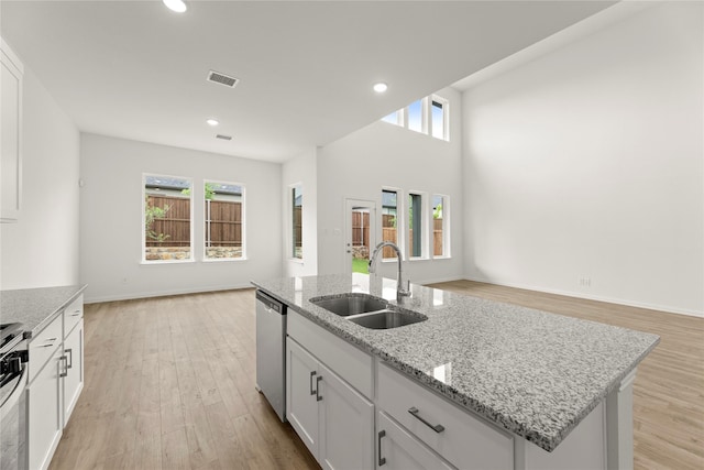 2720 Green River Rd, Royse City, TX 75189 - kitchen with a sink, stainless steel appliances, open floor plan, white cabinets, and light wood-type flooring