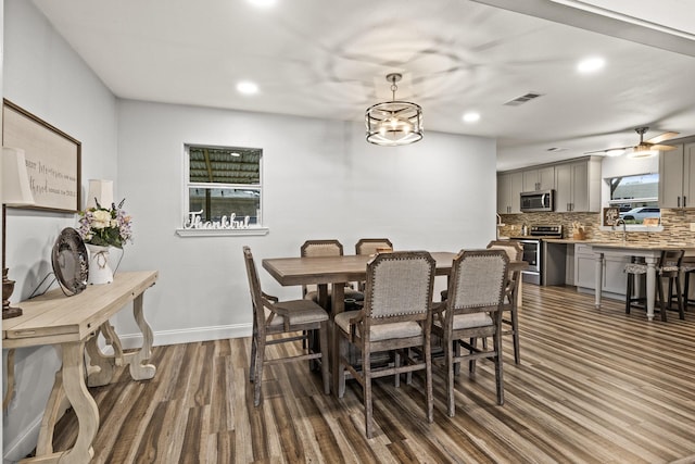 dining space with dark wood-style floors, baseboards, visible vents, and recessed lighting